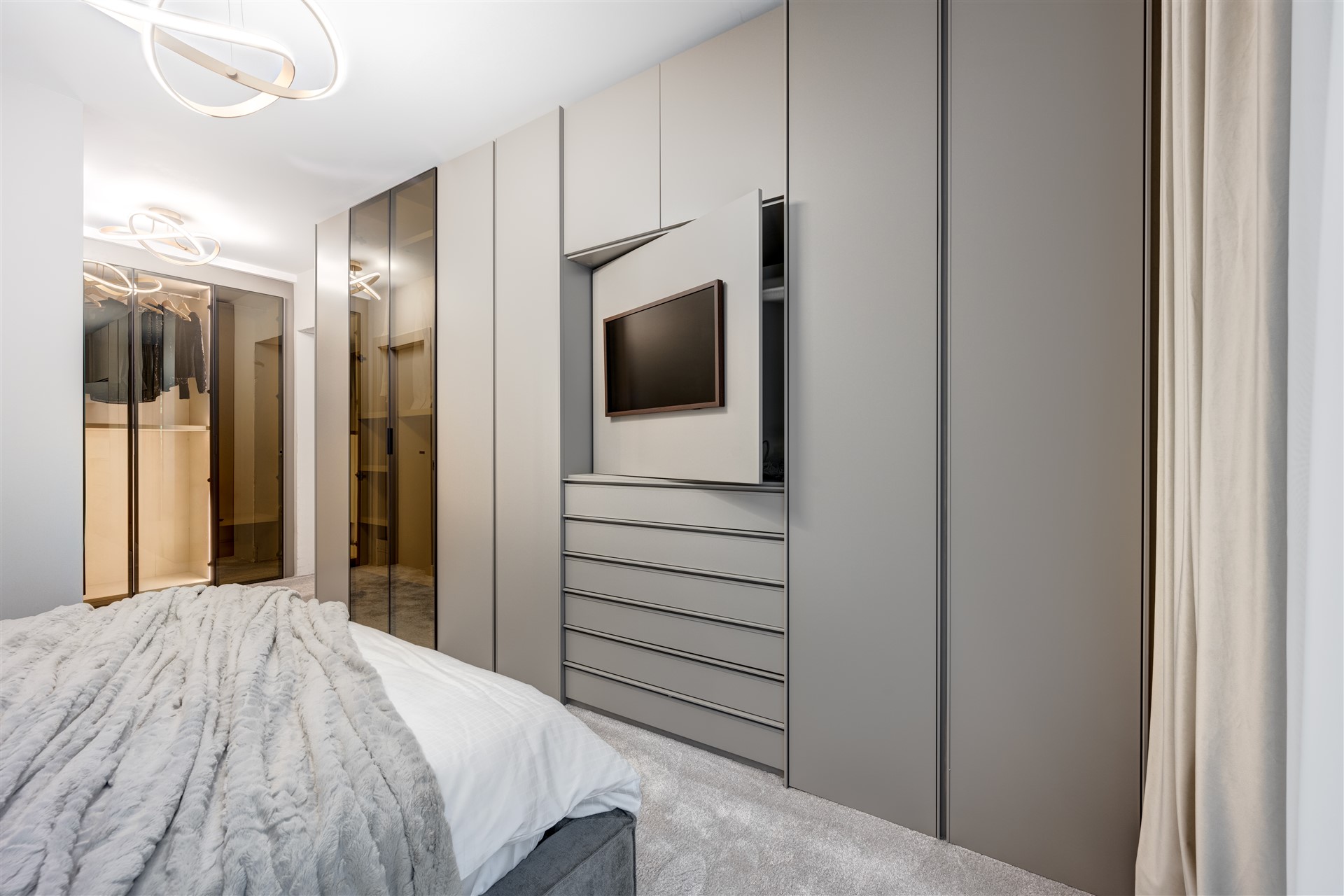 Spațiu de dormitor în showroom ARQA Jolie Village, cu mobilier de calitate, iluminare caldă și un design rafinat.